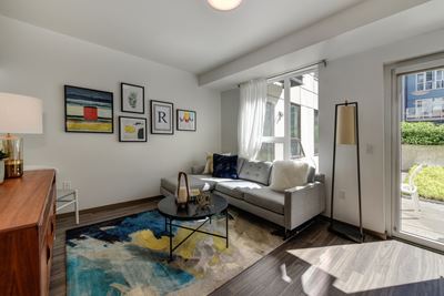 Living Room with Patio Door, Hardwood Inspired Floor, White Sofa and Colorful Rug